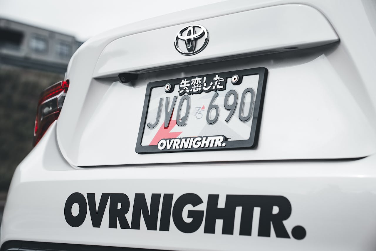 A detailed view of a cars custom license plate with Japanese characters.